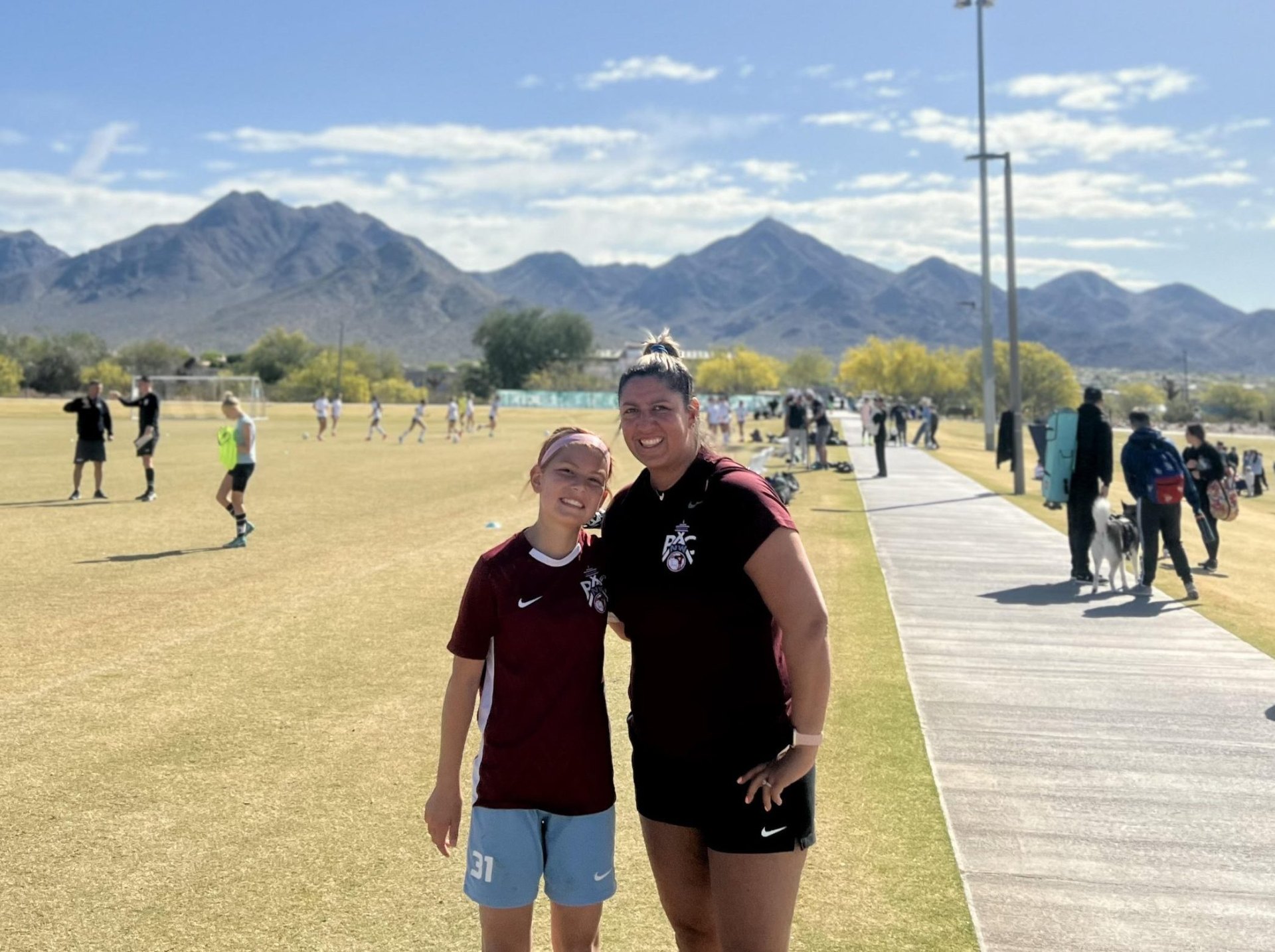 Coach Savanna and her daughter Annabelle at a soccer field at sunset