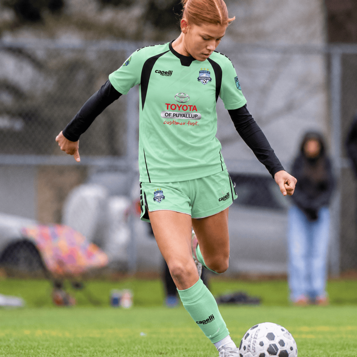 Youth player in teal kit passing a ball